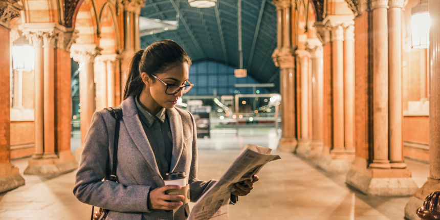 women reading newspaper in grand hall