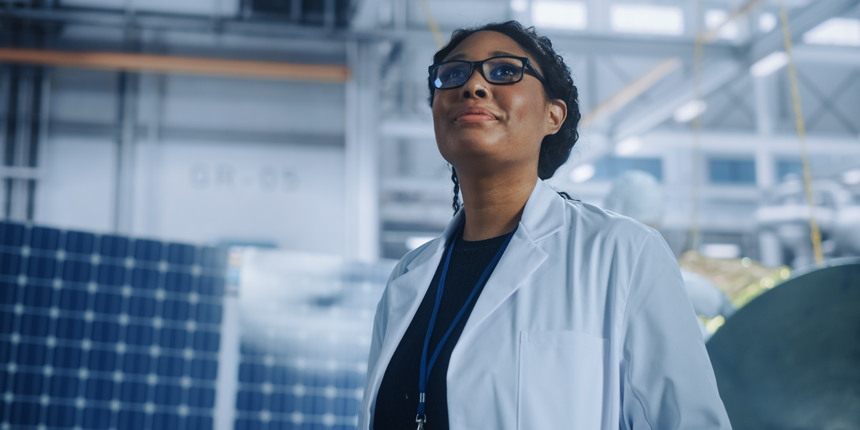 Black female engineer looks around in wonder at the Aerospace Satellite Manufacturing Facility. 