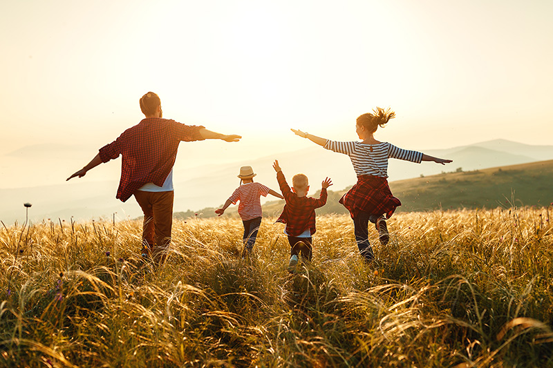 Famille heureuse : mère, père, enfants fils et fille dans la nature au coucher du soleil