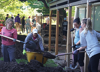 Engineers Canada’s Michaela Ryan, Joan Bard Miller, Julie Sendrowicz, and Alison Peverley work to grade and landscape the community yard at one of Ottawa Community Housing’s buildings on June 25, 2024. 
