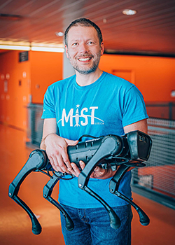 A man standing and holding a large robot