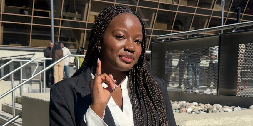 A professional woman with braids, dressed in a suit and tie.