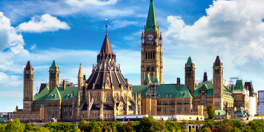 The Canadian Parliament Buildings in Ottawa, featuring green copper roofs, gothic architecture, and a tall central clock tower with the Canadian flag.