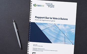 Un document à reliure spirale intitulé « Path Forward Report: Futures of Engineering Accreditation » d'Ingénieurs Canada, posé sur une surface sombre à côté d'un stylo argenté.