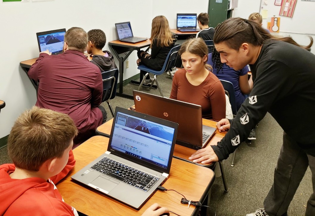 enfants travaillant sur des ordinateurs avec des enseignants