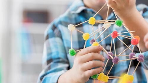 hands holding model of molecular structure