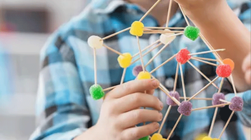 hands holding model of molecular structure