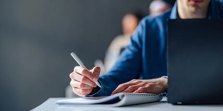 Image d'une personne à son bureau avec un stylo
