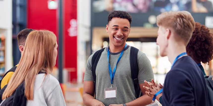 Group Of College Student Friends Meeting And Talking In Busy Communal Campus Building