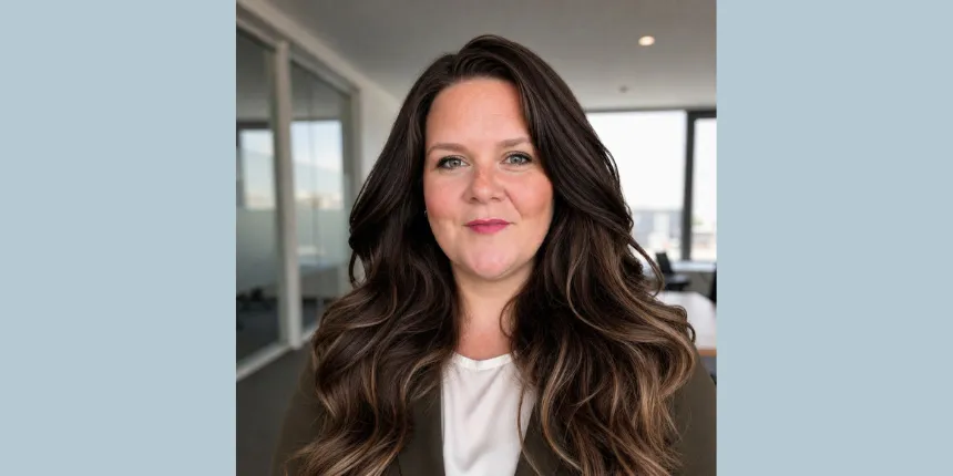 A professional headshot of Laura Paul from Engineers Canada. She is smiling slightly and has long, wavy brown hair, pictured in a modern office setting with large windows in the background.