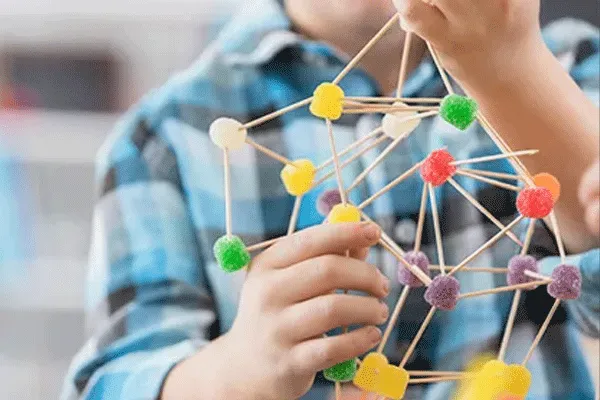 hands holding model of molecular structure